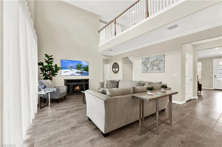 Tiled living room featuring a towering ceiling and ornamental molding