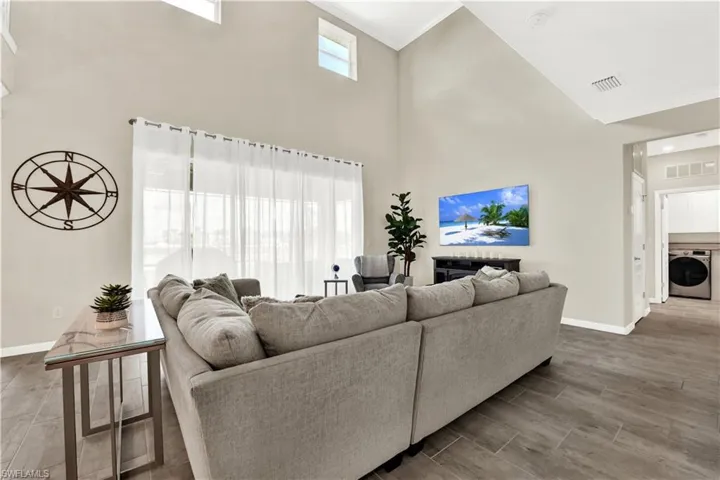 Living room with washer / dryer, a high ceiling, and hardwood / wood-style flooring