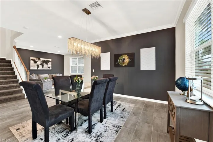 Dining room with crown molding, hardwood / wood-style flooring, and a chandelier