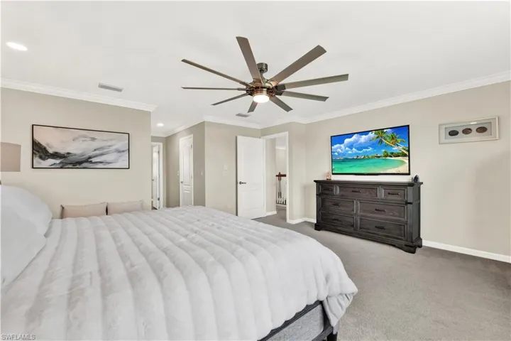 Bedroom featuring carpet, ceiling fan, and crown molding