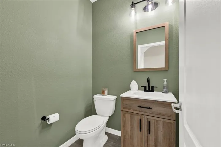Bathroom featuring tile flooring, toilet, and vanity