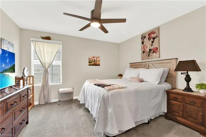 Bedroom featuring light carpet and ceiling fan