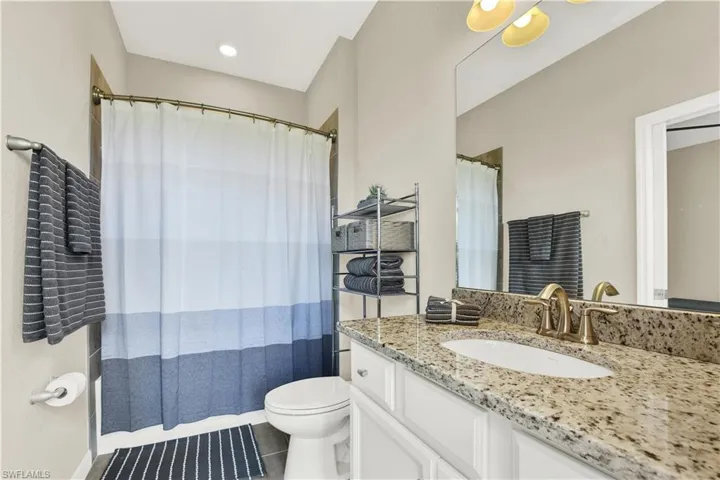 Bathroom featuring tile floors, oversized vanity, and toilet