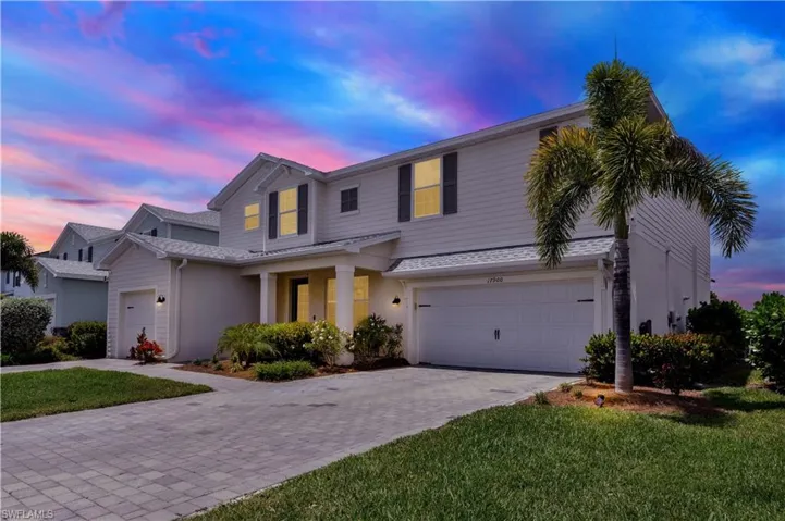 View of front of property with a garage and a yard