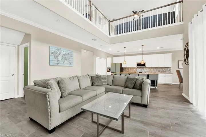 Living room with a towering ceiling and ornamental molding