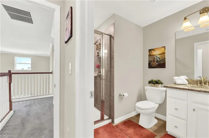 Bathroom featuring walk in shower, toilet, and oversized vanity