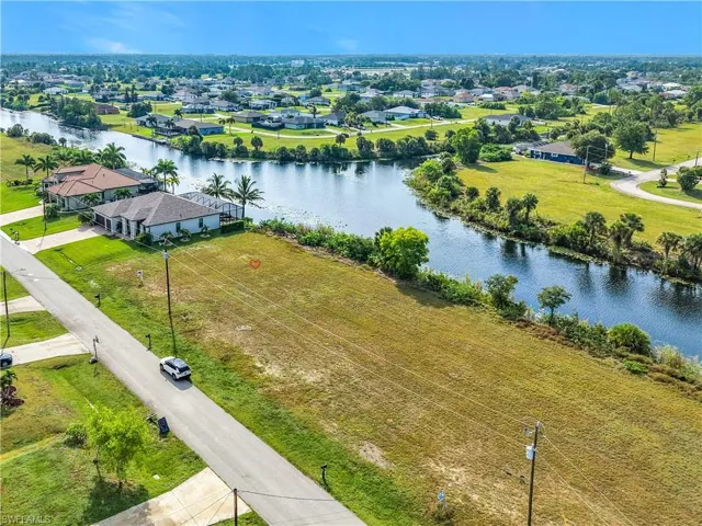 View of can intersection at Brothers Canal and Slough CanalExpansive cleared parcel featuring canal frontage, a verdant green lawn, and surrounding residential properties