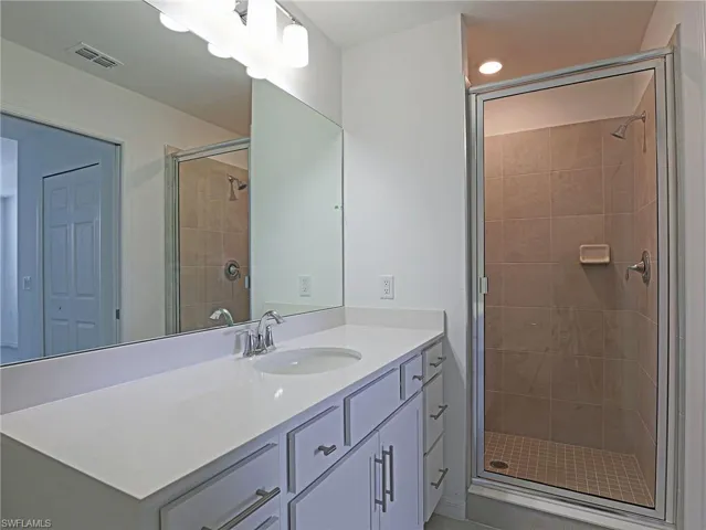 Full bath with a stall shower and vanity