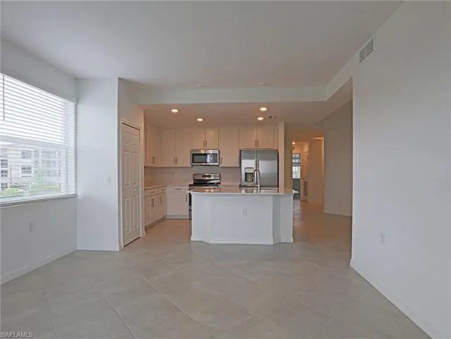 Kitchen with stainless steel appliances, a kitchen island with sink, plenty of natural light, recessed lighting, and light tile patterned flooring