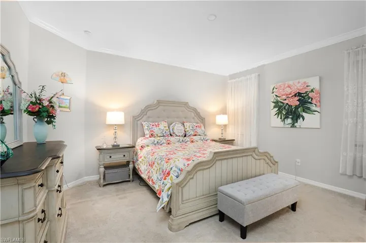 Carpeted bedroom featuring crown molding