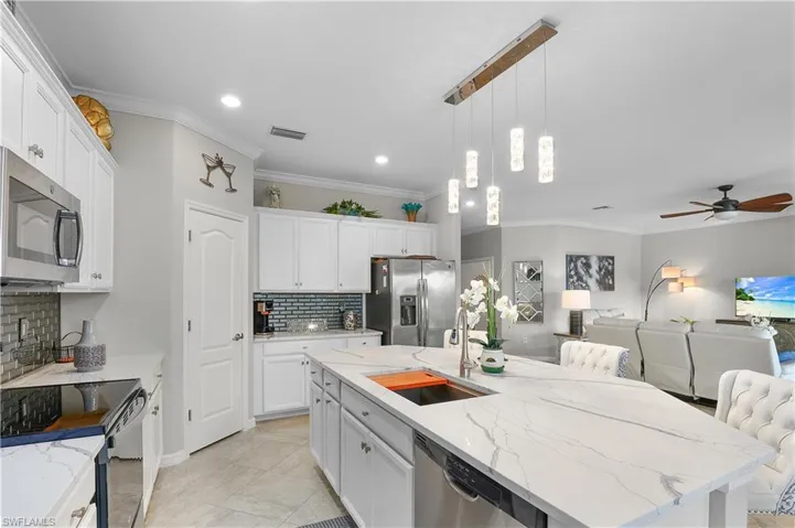Kitchen featuring a kitchen island with sink, decorative backsplash, appliances with stainless steel finishes, and sink