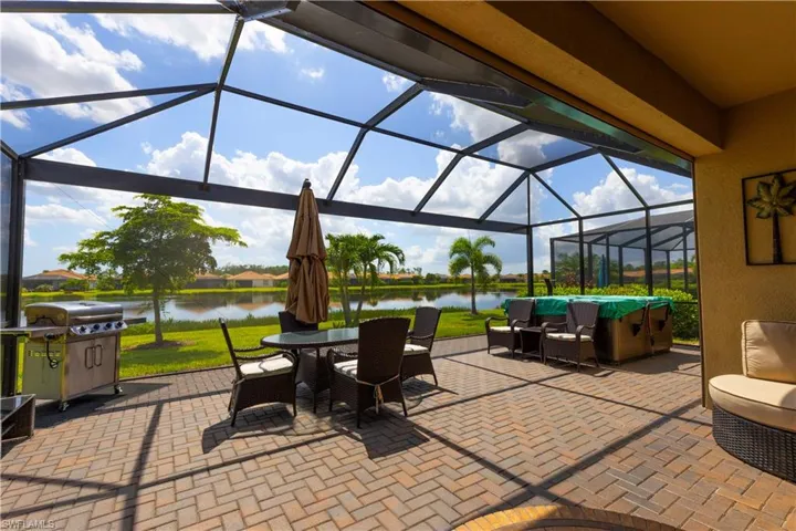 View of patio / terrace with a lanai, a water view, and grilling area