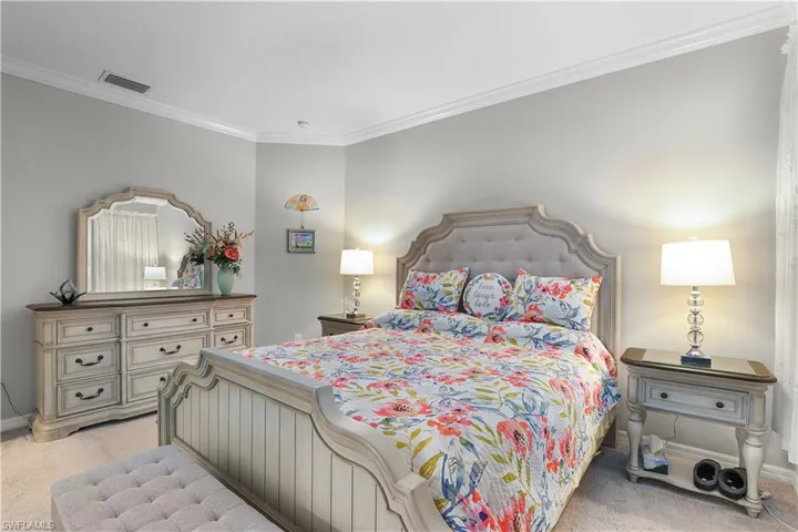 Carpeted bedroom featuring crown molding