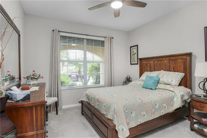 Bedroom with ceiling fan and light carpet