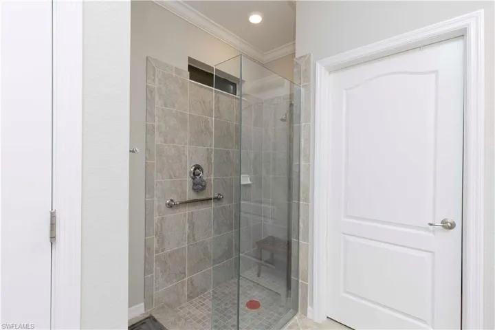 Bathroom with an enclosed shower and crown molding