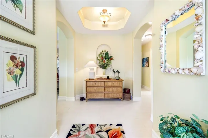 Corridor with a tray ceiling and arched walkways