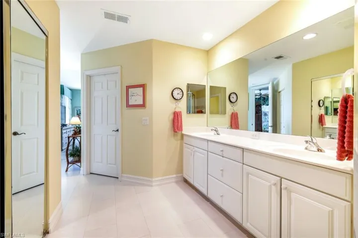 Bathroom featuring double vanity, light tile patterned flooring, and recessed lighting