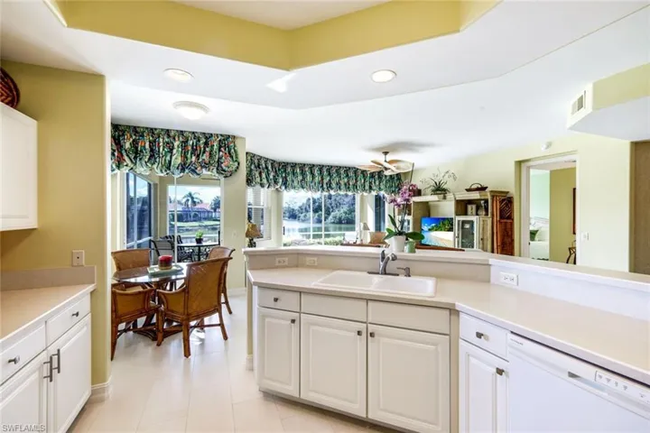 Kitchen with dishwasher, white cabinetry, light countertops, and recessed lighting