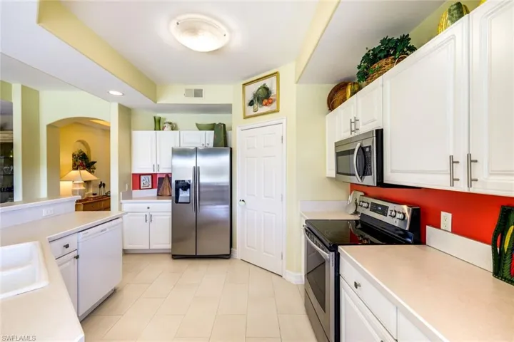 Kitchen with stainless steel appliances, white cabinetry, light countertops, and recessed lighting