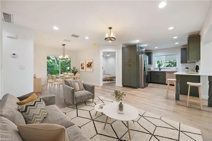 Living room featuring plenty of natural light, recessed lighting, light wood-style flooring, and a chandelier