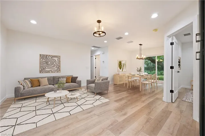 Living room featuring a chandelier, recessed lighting, and light wood finished floors