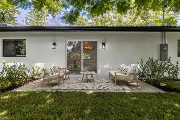 Back of house featuring stucco siding, a patio area, and a yard
