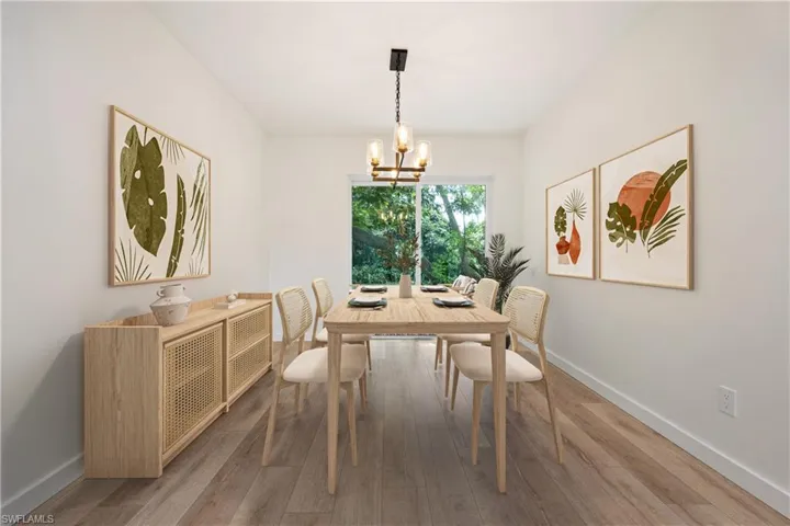 Dining space with wood finished floors and a chandelier