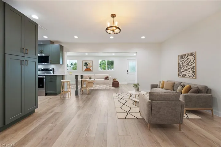 Living area with recessed lighting, light wood finished floors, and a chandelier