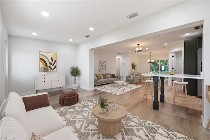 Living area with recessed lighting, a chandelier, and light wood-style flooring