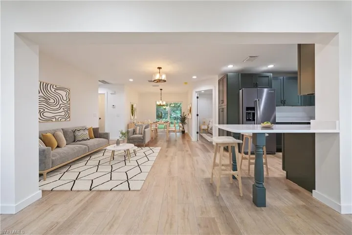 Living room with recessed lighting, a chandelier, and light wood-style flooring