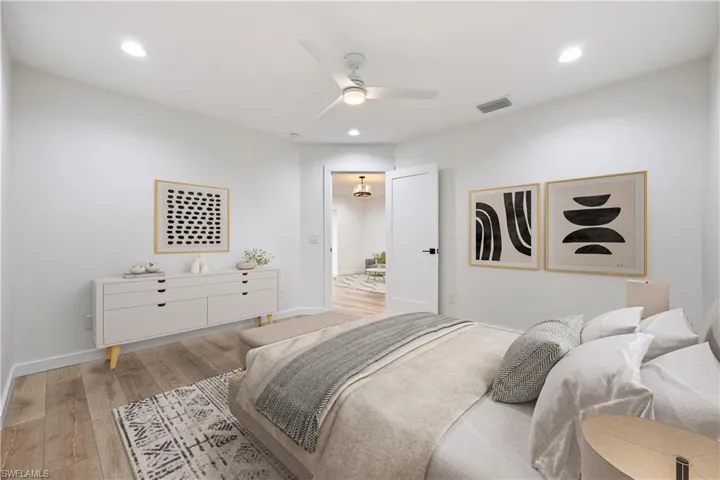 Bedroom with light wood-style flooring, ceiling fan, and recessed lighting