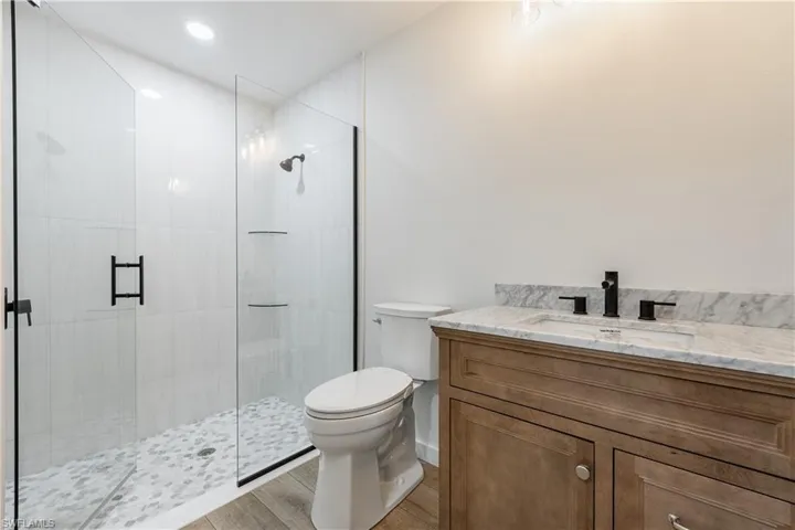 Full bathroom featuring vanity, a stall shower, light wood-style floors, and recessed lighting