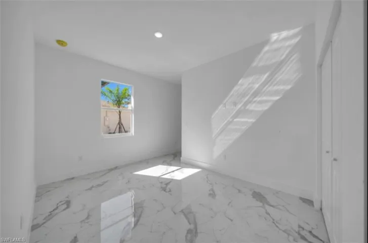 Unfurnished room featuring marble finish floors and recessed lighting