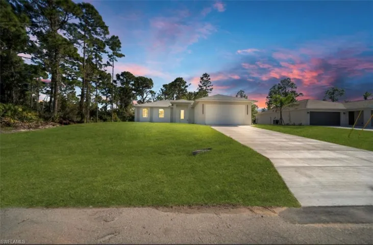 Single story home featuring concrete driveway, a yard, and a garage