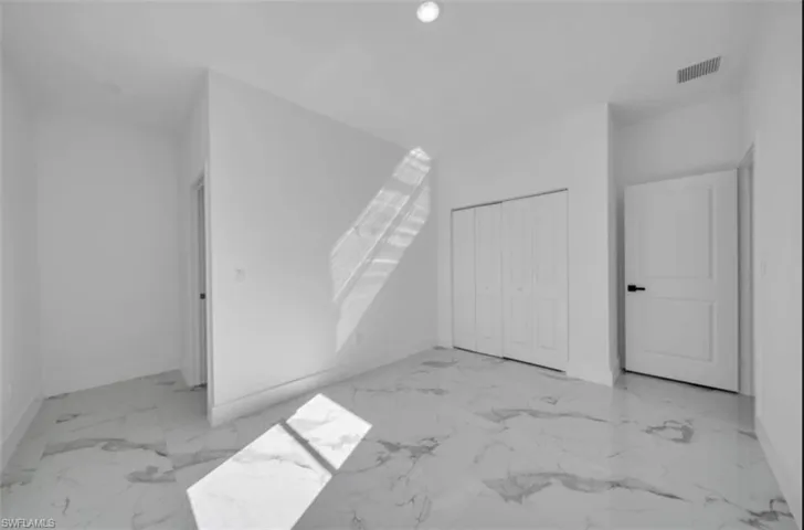 Additional living space with light marble finish flooring and recessed lighting