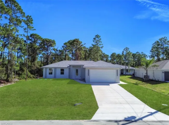 Ranch-style home with concrete driveway, a front lawn, an attached garage, and stucco siding