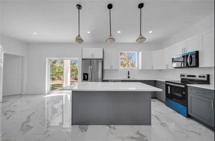 Kitchen with stainless steel appliances, white cabinets, decorative light fixtures, healthy amount of natural light, and recessed lighting
