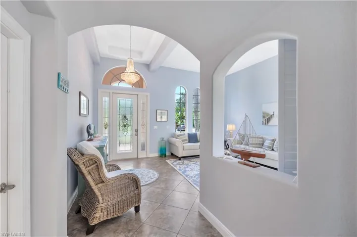 Tiled entryway with baseboards and a tray ceiling