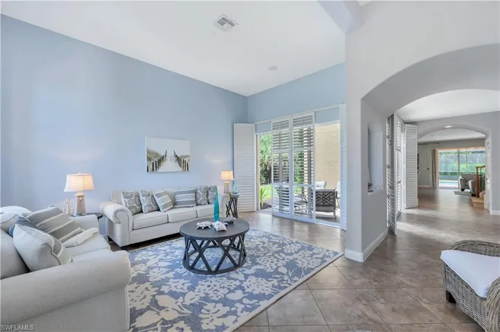 Tiled living room featuring arched walkways and baseboards