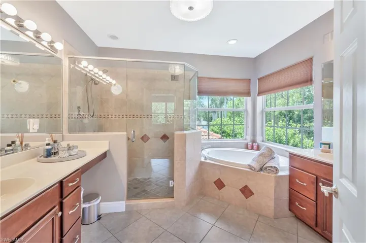 Full bath with vanity, tile patterned flooring, a bath, and a stall shower