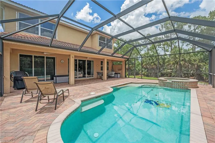 View of swimming pool featuring ceiling fan, a pool with connected hot tub, and a patio area