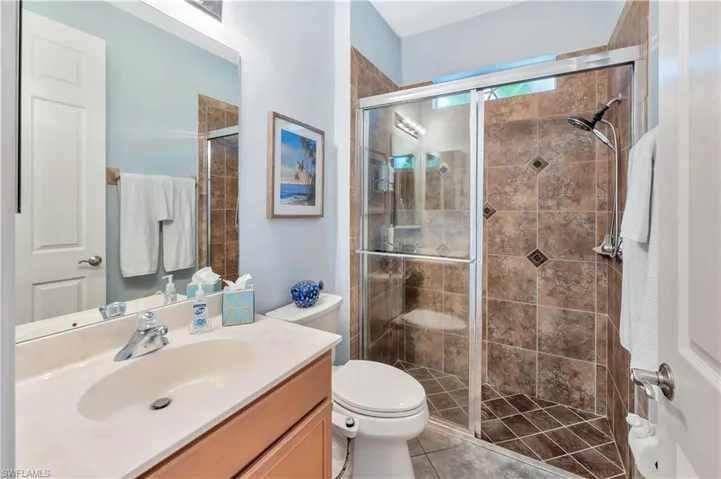 Full bath featuring vanity, a stall shower, and tile patterned flooring