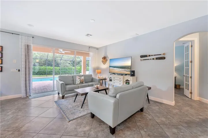 Tiled living room with arched walkways and a ceiling fan