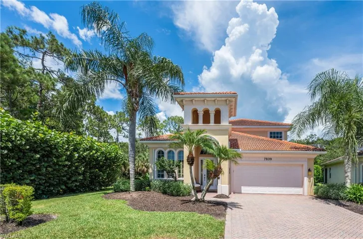 Mediterranean / spanish-style house with decorative driveway, stucco siding, a tiled roof, an attached garage, and a front lawn