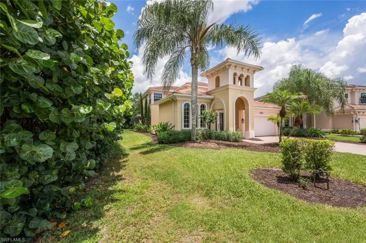 Mediterranean / spanish home featuring driveway, stucco siding, a front lawn, an attached garage, and a tile roof