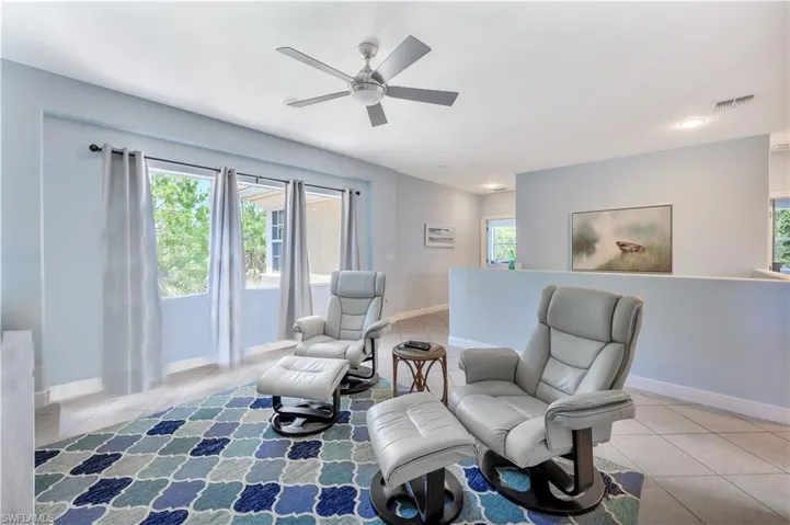 Sitting room featuring tile patterned floors and ceiling fan