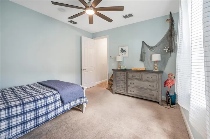 Bedroom with carpet flooring, multiple windows, and a ceiling fan