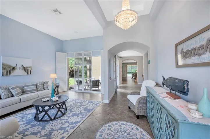 Tiled living room with arched walkways and a chandelier