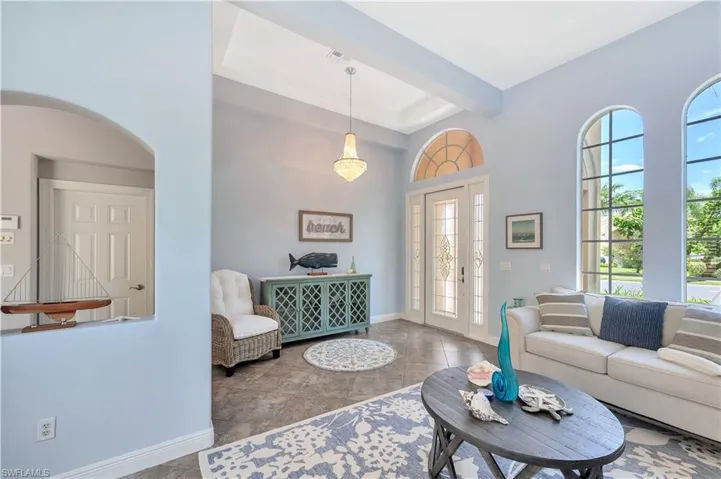 Living room featuring baseboards and a towering ceiling