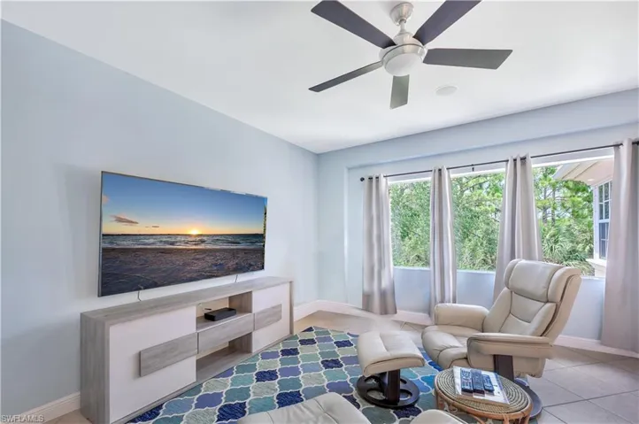 Living area with baseboards and ceiling fan
